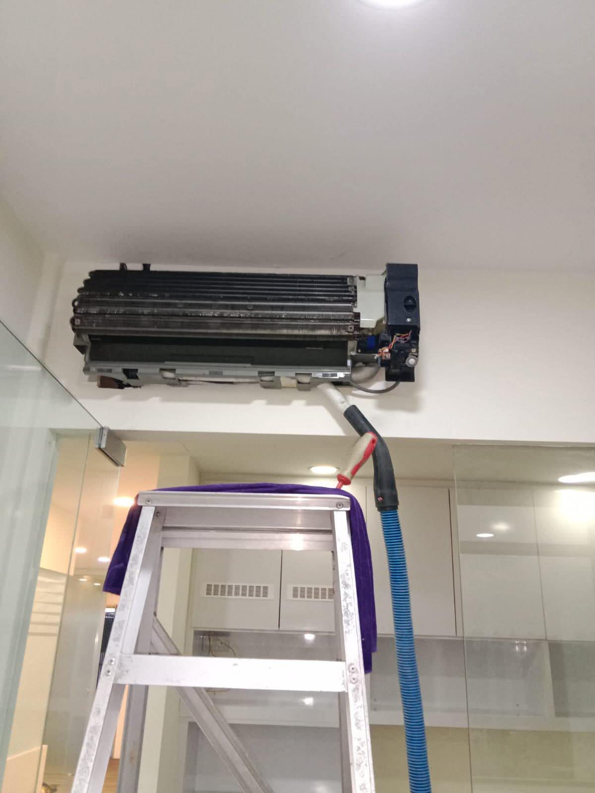 Technician servicing an indoor aircon unit