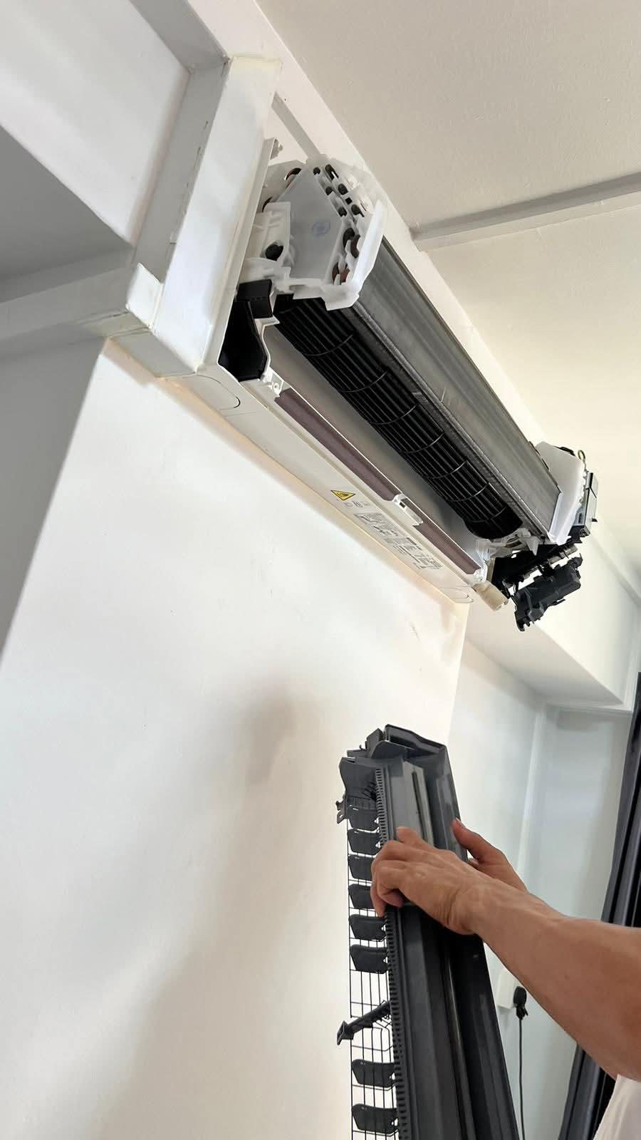 Technician holding a disassembled fan coil