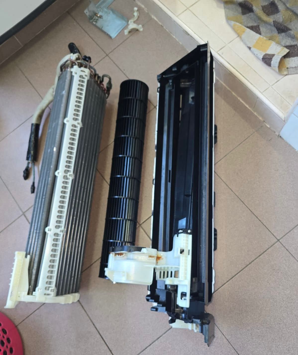 Disassembled aircon parts laid out for cleaning